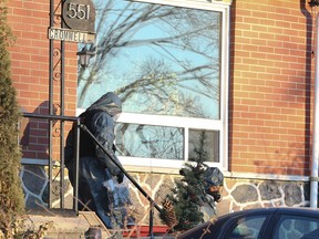 A Durham Regional Police drug enforcement unit officer leaves an Oshawa home on Jan. 16, 2015. (Veronica Henri/Toronto Sun)