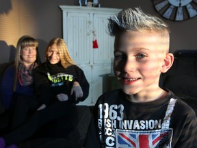 Logan Graham, 8, who has autism spectrum disorder, is pictured with his mom Glenda and sister Ruby, 10, at their home in Calgary, on January 16, 2015. (Mike Drew/QMI Agency)