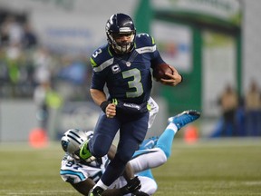 Seahawks quarterback Russell Wilson runs the ball against the Panthers defence during second half NFC playoff action in Seattle on Jan. 10, 2015. (Steven Bisig/USA TODAY Sports)