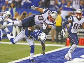 New England Patriots’ Rob Gronkowski jumps over the back of Colts’ Vontae Davis to score a touchdown earlier this season. (USA TODAY SPORTS)