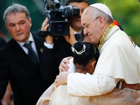 Pope Francis embraces a boy and a girl during a meeting with young people at Manila university, January 18, 2015. (REUTERS/Stefano Rellandini)