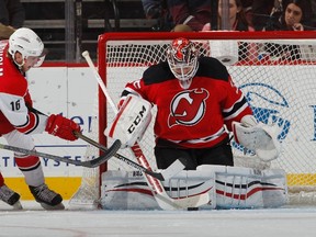 Goalie Cory Schneider #35 of the New Jersey Devils stops a shot by Elias Lindholm #16 of the Carolina Hurricanes in the second period of an NHL hockey game at Prudential Center on December 23, 2014 in Newark, New Jersey.  (Paul Bereswill/Getty Images/AFP)