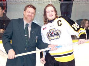 Tournament director Mark Colbran presents Aurora Tigers captain Greg Martin with a Silver Stick after his club won the midget AA championship. The Tigers defeated the Markham Islanders 4-3 Sunday afternoon. (TERRY BRIDGE/THE OBSERVER)