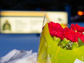 Fresh flowers were lain outside of the St. Albert RCMP detachment at 96 Bellerose Drive in St. Albert, Alta., on Saturday, Jan. 17, 2015. Two officers were shot at the Apex Casino in the city near Edmonton in the early morning hours of Jan. 17 by a suspect police confirm is deceased. Ian Kucerak/Edmonton Sun/ QMI Agency