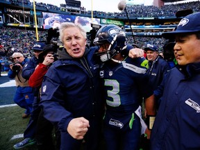 Head coach Pete Carroll and Russell Wilson #3 of the Seattle Seahawks celebrate after the Seahawks 28-22 victory in overtime against the Green Bay Packers during the 2015 NFC Championship game at CenturyLink Field on January 18, 2015 in Seattle, Washington. (Kevin C. Cox/Getty Images/AFP)