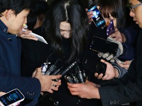 Cho Hyun-ah, centre, also known as Heather Cho, daughter of chairman of Korean Air Lines, Cho Yang-ho, is surrounded by media as she leaves for a detention facility after a court ordered her to be detained, at the Seoul Western District Prosecutor's office December 30, 2014. (REUTERS/Kim Hong-Ji)