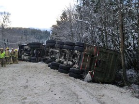 Firefighters survey the scene of a tractor-trailer rollover along Hwy. 309 near l'Ange Gardien on Monday. (MRC des Collines Police submitted image)
