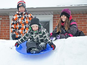 Taitum Vessie slides down a snow hill in his backyard as mom Kim and brother Nolan look on, last Saturday, Jan. 17. The family built the snow slide earlier in the month for Taitum and his two brothers to enjoy the outdoors this winter. KRISTINE JEAN/MITCHELL ADVOCATE