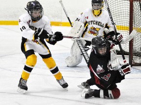 Joe Murray (12) of the Goderich Pee Wee AE is tangled up in Mitchell's Kurtis DeJong's stick during action from Game 1 of their OMHA Group 4 AE playoff series last Tuesday, Jan. 13. Mitchell won 2-1. ANDY BADER/MITCHELL ADVOCATE