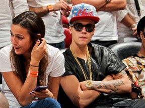 Recording artist Justin Bieber, right, looks on as the Indiana Pacers play the Miami Heat in Game Seven of the Eastern Conference Finals during the 2013 NBA Playoffs on June 3, 2013 at American Airlines Arena in Miami, Florida. (Issac Baldizon/NBAE via Getty Images/AFP)