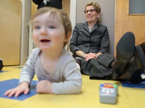 Ontario Premier Kathleen Wynne sits with 11-month-old Olivia Lake-McIntosh at the child-care centre at the YMCA of Kingston Monday, Jan. 19, 2015. Wynne was in Kingston to announce a planned raise to the wages paid to child-care workers.
(Elliot Ferguson/The Whig-Standard)