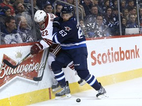 Winnipeg Jets defenceman Ben Chiarot (right) pins Arizona Coyotes forward Brandon McMillan against the glass during NHL action at MTS Centre in Winnipeg, Man., on Sun., Jan. 18, 2015. Kevin King/Winnipeg Sun/QMI Agency