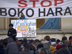 Demonstrators holds placards and banners reading "I am Nigerian" (L) and "Stop Boko Haram" during a gathering at the trocadero place in Paris on January 18, 2015 to protest against Boko Haram islamists after a large-scale attack in Baga, which straddles the borders of Chad, Nigeria, Niger and Cameroon, where as many as 2,000 people were massacred in a raid on January 7, 2015. (AFP PHOTO/LIONEL BONAVENTURE)
