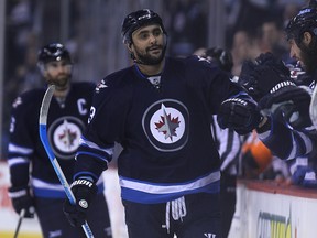 Winnipeg Jets forward Dustin Byfuglien high-fives at the bench after scoring against the Philadelphia Flyers during NHL action at MTS Centre in Winnipeg, Man., on Sun., Dec. 21, 2014. Kevin King/Winnipeg Sun/QMI Agency