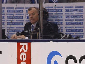 Penalty timekeeper Dave Keon Jr., son of the Leaf great, looks at a Leaf sweater that was thrown on the ice in the second period as Maple Leafs lost 4-1 to the Carolina Hurricanes at the Air Canada Centre in Toronto on Monday January 19, 2015. (Michael Peake/Toronto Sun)