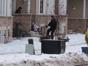 A bloody man is removed from a home by Kingston Police on Monday, Jan 19, 2015. (Elliot Ferguson/The Whig-Standard)