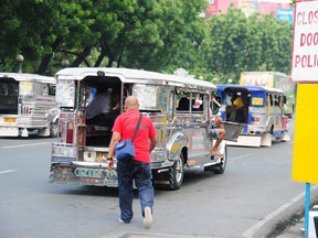 A rider prepares to hop aboard a Jeepney in Alabang, a city south of Manila. Jeeneys are a common and cheap form of transportation in the Philippines. (Bryan Passifiume/QMI Agency)