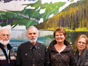 (L to R) John Hancock, Mike Judd, Rebecca Holand and Linda Anderson Stewart are the four artists featured in the Art in the Library gallery on until April 24. The four artists are pictured here in front of Judd’s Calm Day on Cameron Lake oil on canvas painting. Greg Cowan photo/Pincher Creek Echo.