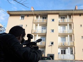 A man films on January 20, 2015 a building in Beziers, where a Russian Chechen suspected of preparing a terrorist attack was living before his January 19 arrest. Five Russian Chechens were placed under custody in Beziers and Saint-Jean-de-Vedas, outside Montpellier.    AFP PHOTO / PASCAL GUYOT