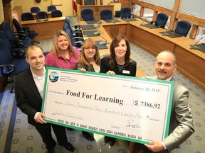 Mayor Taso Christopher (first from right) presents a cheque for $7,386, the amount collected in Belleville during the 2014 Feed the Meter campaign, in support of The Hastings and Prince Edward Learning Foundation.  Also pictured are (first from left) Belleville sponsors Adrian DeGroot, from Wilkinson Chartered Accountants, and Kim McCaw, of Adecco, with Kellie Brace, the Food for Learning co-ordinator and Maribeth deSnoo, executive director of the learning foundation.
