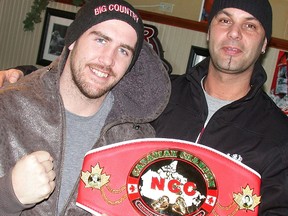 Canadian heavyweight professional boxing champion Dillon (Big Country) Carman, left, shows his belt to local fight fan Joe Roberto during a promotional appearance Tuesday at Slapshots Sports Bar and Grill. (Paul Svoboda/The Intelligencer)