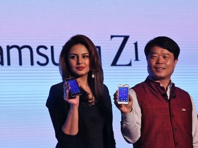 Hyun Chil Hong (R), president and chief executive of Samsung India Electronics, and Bollywood actress Huma Qureshi hold the Samsung's new Z1 smartphones at its launch in New Delhi in this Jan. 14, 2015 file photo. REUTERS/Adnan Abidi/Files