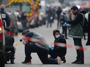 Police investigators examine the impacts from machine gun fire on the front of a police vehicle in the street near the Paris offices of Charlie Hebdo, after 12 people were killed in a recent attack on the  satirical newspaper. Tarek Fatah writes the success of violent Islamists is partly due to a grand betrayal of civil society by the political left in the western democracies. (REUTERS PHOTO)