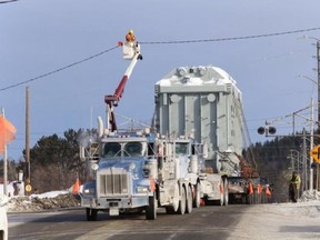 Hydro crews lift lines to permit the movement of a 400-ton, 25-foot-high transformer from Capreol to the Hanmer transformer station on Wednesday morning. The task required three transport trucks and was expected to take up to five hours. John Lappa/The Sudbury Star/QMI Agency
