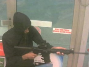 One of the suspects appears to cock the assault rifle at one point. (Screengrab from video provided by Toronto Police)