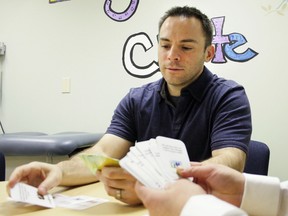 Alberta Health Services's Pediatric Centre for Weight and Health director Geoff Ball is handed a conversation card. Ball and fellow researchers developed the cards to help parents talk about their child's weight management.