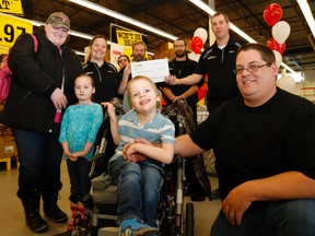 Luke Hendry/The Intelligencer
Anden Smoke-Maracle sits surrounded by his family and staff of Marc's No Frills after staff presented a $20,000 cheque from the President's Choice Children's Charity to the family in Belleville. The family will use the funds to buy their first wheelchair-accessible van. From left are Anden's mother, Kristen Smoke, his sister Kasha, No Frills co-owner Jenny Daoust, staff Kylie Young, Rob Forbes and Jeff Foshay, co-owner Marc Daoust and Anden's father, Kevin Maracle.