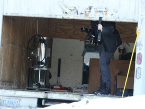 An Ottawa police officer photographed the contents of the suspect's cube van, found in the rear parking lot of the Chimo Hotel. Cops said no hazardous substances were found in the van or Phillips' 6th floor hotel room.DOUG HEMPSTEAD/Ottawa Sun