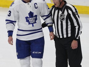 Dion Phaneuf of the Toronto Maple Leafs is escorted off the ice after fighting along the boards with Milan Michalek of the Ottawa Senators on Jan. 21, 2015, in Ottawa. (TONY CALDWELL/QMI Agency)