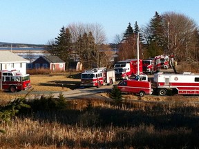 An RCMP police cruiser and fire vehicles sit near cottages in Grand Desert, N.S. near Halifax on Wednesday Jan. 21, 2015. Police and firetrucks blocked off access to the red cottage where a cache of chemicals was found. Ottawa police arrested the suspect who prompted an evacuation at east-end hotel. Kris Sims/QMI Agency