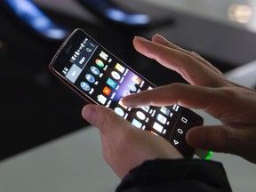 An attendee tries out a LG G Flex 2 curved smartphone during the 2015 International Consumer Electronics Show (CES) in Las Vegas, Nevada Jan. 6, 2015. REUTERS/Steve Marcus