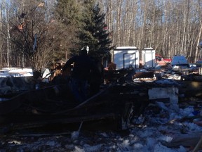 Family members of Randy Johnston looks at the remains of Johnston home. Perry Mah/Edmonton Sun