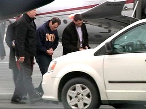 Chris Phillips is escorted by authorities after arriving at Halifax International Airport on Thursday Jan. 22, 2015. Phillips is charged in Nova Scotia with possession of a weapon, a chemical Osmium Tetroxide, and threat to police. (Kris Sims/QMI Agency)