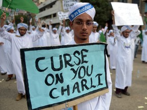 Pakistani Islamists carry placards as they march during a protest against the printing of satirical sketches of the Prophet Mohammed by French magazine Charlie Hebdo in Karachi on January 22, 2015.  Thousands of people marched through Pakistan's southern megacity in the largest protest yet against French satirical magazine Charlie Hebdo for publishing cartoons of the Prophet Mohammed.  (AFP PHOTO / Rizwan TABASSUM)