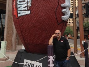 Marty Forbes standing in front of a really big football. Photo Supplied