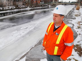Luke Hendry/The Intelligencer
Belleville public works employee Steve Gordon crouches along the east bank of the Moira River in downtown Belleville Friday. There is still some open water on the river, but no significant buildup of frazil ice crystals, a possible flood hazard.