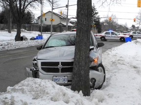 A stolen car is crumpled against a tree following a pharmacy robbery that led to a crime spree Friday morning. (KATE DUBINSKI, The London Free Press)