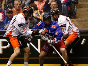 Buffalo Bandits’ Kevin Brownell (left) and Dhane Smith try to contain the Rock’s Jesse Gamble during Toronto’s National Lacrosse League home opener on Jan. 23 at the ACC. (Jack Boland, Toronto Sun)