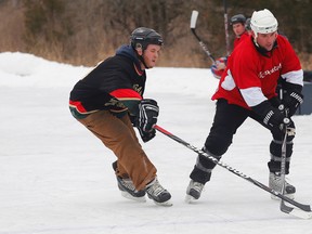 Josh Kuipers, left, of Millgan New Home Construction challenges Lance Holoway of McDougall Insurance during the CFB Trenton Pond Hockey Classic charity tournament in Batawa this past weekend. - Luke Hendry/The Intelligencer