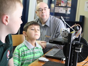 Six-year olds Sean O'Rourke, left, and Thomas Werden watch with high school technology teacher Kirk Charette as a 3D printer begins working at the Sarnia Library. Charette is demonstrating the technology Saturdays at the library until Feb. 28.TYLER KULA/ THE OBSERVER/ QMI AGENCY