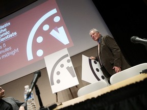 Richard Somerville (R), research professor at Scripps Institution of Oceanography, unveils an updated version of the "Doomsday Clock" during a press conference held by the Bulletin of the Atomic Scientists January 22, 2015 in Washington, DC. Win McNamee/Getty Images/AFP