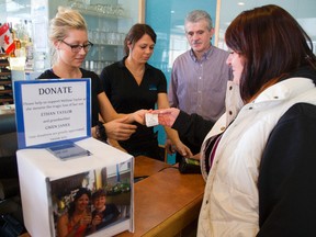 The Malibu Restaurant has a donation box out on the counter for Melissa Taylor, an employee who lost her son Ethan Taylor and grandmother Gwen James in a recent fire in Mt. Brydges fire Christine Homolay, left, and Dina Protopapas work behind the counter with owner Gus Kourtesis with a regular customer Sherri Brown of London, right. Mike Hensen/The London Free Press/QMI Agency