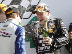 Jamie McMurray, co-driver of the No. 02 Ford EcoBoost Daytona Prototype, gets doused with champagne after winning the Rolex 24 at Daytona on Sunday in Florida. The team also included Scott Dixon, Tony Kanaan and Kyle Larson. (AFP/PHOTO)