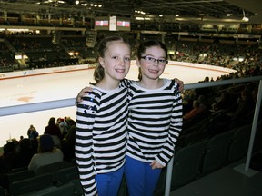 Cousins Mackenna Dunkley, left, 10, and Olivia Lord, 10, visiting from Stirling and Trenton at the Canadian Tire National Skating Championships at the Rogers K-Rock Centre in Kingston on Saturday. (Steph Crosier/The Whig-Standard)