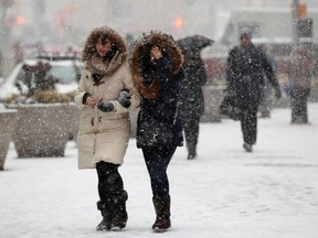 People walk through heavy falling snow in Times Square in New York January 26, 2015.   REUTERS/Mike Segar