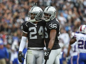 Oakland Raiders free safety Charles Woodson (24) is congratulated by defensive back Ras-I Dowling (36) for an interception against the Buffalo Bills during the first quarter at O.co Coliseum. (Kyle Terada-USA TODAY Sports)